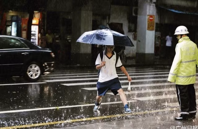 Học sinh tới trường thi trong trời mưa nặng hạt ở Quảng Châu.