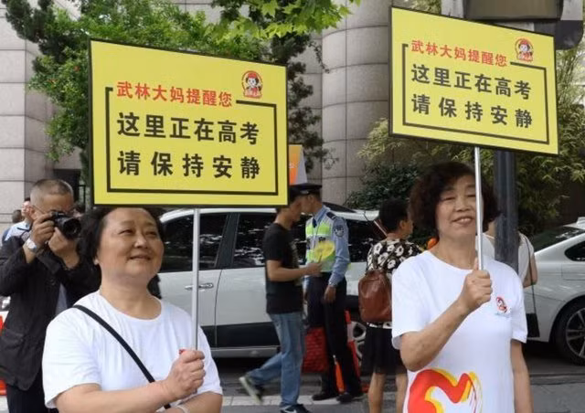 2 phụ nữ cầm biển “Nơi đây đang thi, đề nghị giữ trật tự” tại tỉnh Chiết Giang.