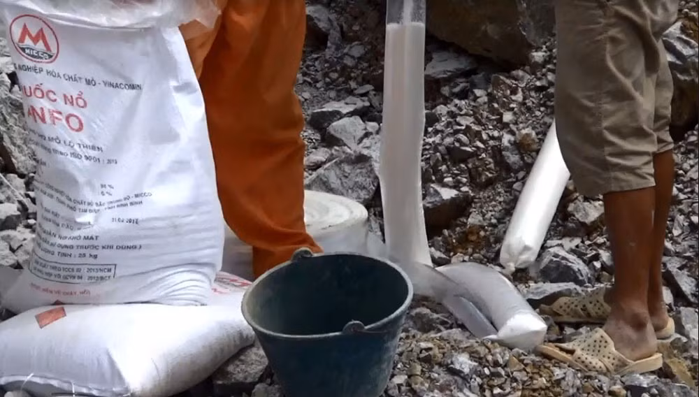 Một cảnh đổ thuốc nổ ra túi thành từng bao nhỏ để nhồi vào lỗ khoan, có thể khiến bất cứ ai xem cũng phải rợn người.