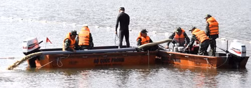 Tình huống bất thường xảy ra: thợ lặn báo vật thể chìm sâu dưới lớp cát ở đáy hồ; thuyền và máy hút cát được huy động hỗ trợ để hút lớp cát phía trên vật thể lạ, tạo điều kiện thuận lợi cho hoạt động trục vớt.