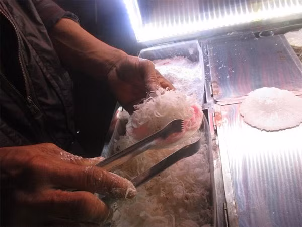  Kẹo tơ hồng: Tại khu chợ đêm Đà Lạt, bạn rất dễ bắt gặp những chiếc xe kẹo tơ hồng rực rỡ màu sắc.Nguyên liệu chính làm nên món kẹo này là những sợi bột màu hồng và dừa khô bào sợi, tất cả được cuốn trong chiếc bánh đa mỏng, có hương vị khá giống với món bò bía ở ngoài Bắc.