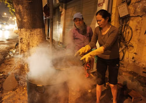 Sau hơn 12 giờ, sáu chị em nhà bà Hương bắt đầu vớt bánh, do nồi nấu bánh chưng quá to và nóng nên mọi người dùng lạnh đổ vào sau đó lại múc nước ra.