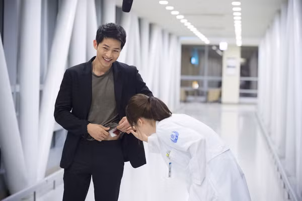 Sự kết hợp áo phông với bộ vest thanh lịch khi chàng tới bệnh viện kiểm tra lại vết thương.