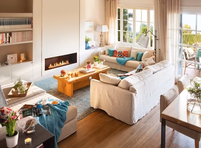 Không gian phòng khách xinh xắn được đặt ngay cạnh cửa sổ. Không gian được bố trí các nội thất cơ bản, màu sắc trung tính nhưng bằng cách nhấn nhá những màu sắc dịu dàng như bàn trà, sàn gỗ, điểm nhấn từ gối tựa đủ để giúp không gian trẻ trung hơn, ấm cúng hơn.