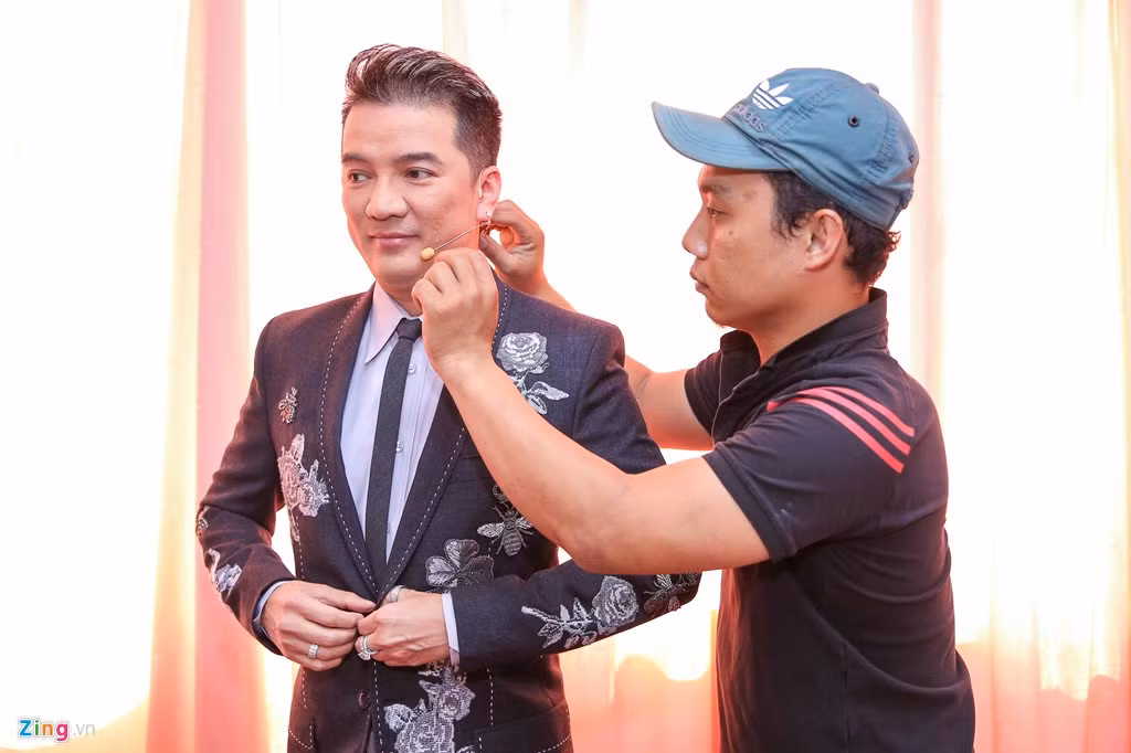 Trong buổi ghi hình, anh diện áo in hoa văn hoa khá điệu đà. Trước đó, nam ca sĩ cũng đến sớm để chuẩn bị làm tóc, trang điểm.