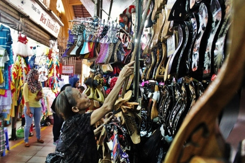 Có đến tận gian hàng của bà lão mới thấy được những đôi guốc đang dần bị mai một, đi vào quên lãng thật sự. Giữa những gian hàng quần áo và vải thì đều là những người trẻ đứng bán, khiến cho tôi cảm thấy thật sự nể phục bà vì dù cho nghề đóng guốc đang đi vào nốt trầm mà bà vẫn luôn ngồi điềm tĩnh, lúc nào lom khom sắp xếp hàng, rồi lại đóng đóng kiểm tra từng đôi guốc, rồi lại ngồi đợi khách đến hỏi rồi chiều chiều lại dọn hàng về.