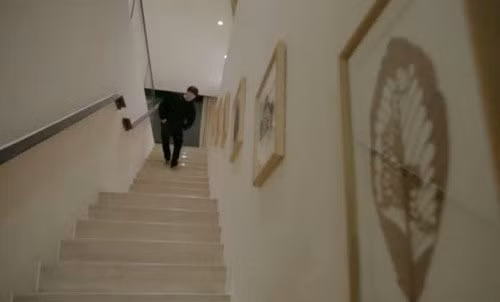 Lối cầu thang được bố trí những bức tranh cùng tông màu với màu sơn.