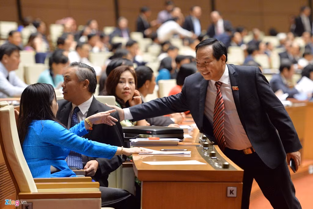 Các đại biểu chào hỏi nhau khi đi qua vị trí chỗ ngồi của người quen.