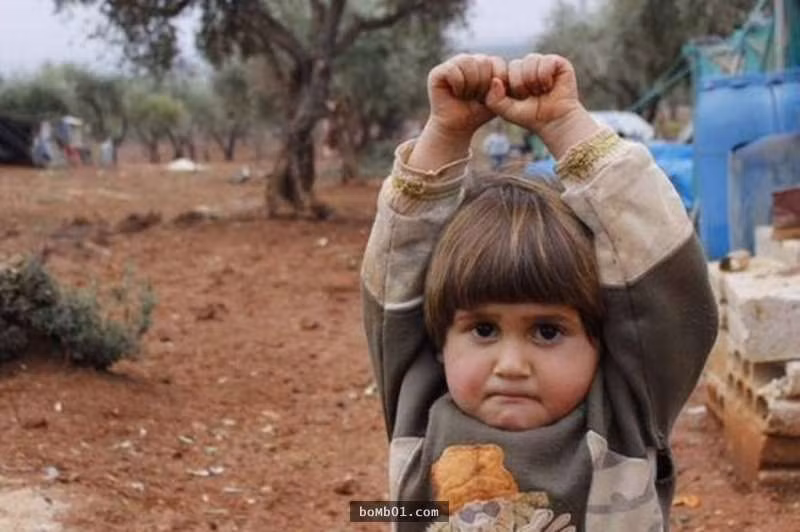 7. Em bé Syria khi nhìn thấy ống kính của thợ ảnh đã sợ hãi giơ tay lên vì tưởng đó là súng.