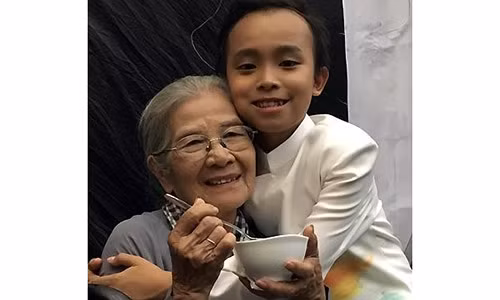 Khi nghệ sĩ Phi Điểu ngồi một mình, em chủ động đi lấy đồ ăn mời bà. Ảnh: Fanpage Hồ Văn Cường