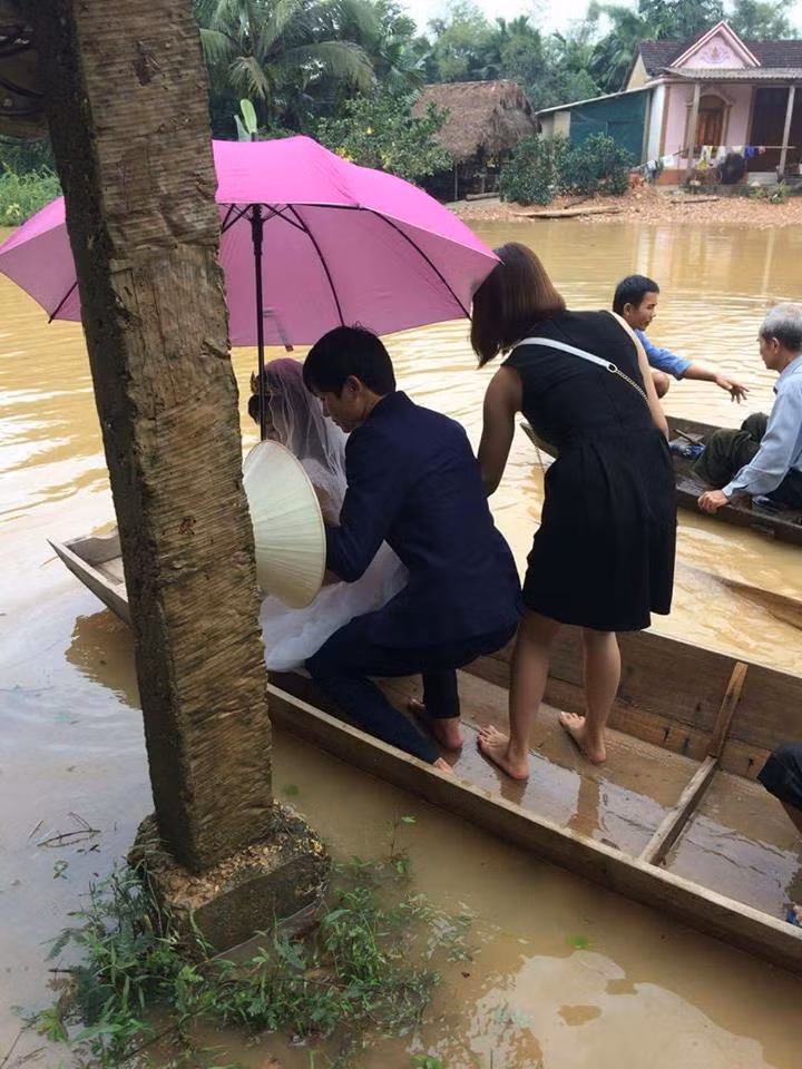 Chú rể giữ cô dâu thăng bằng trên thuyền để rước dâu về.