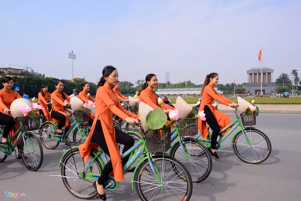 100 nữ sinh với tà áo dài truyền thống đạp xe gắn hoa sen đi qua lăng Chủ tịch Hồ Chí Minh.