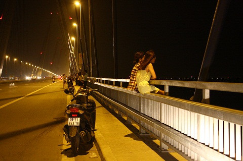 Ngồi vắt vẻo trên lan can cầu.