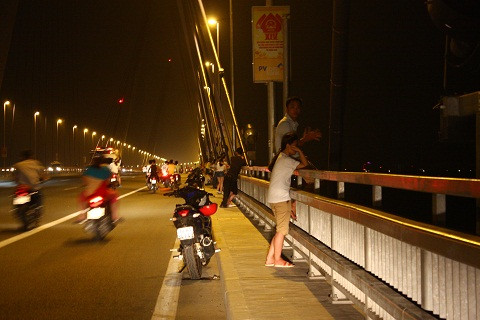 Hình ảnh người đàn ông ngồi trên thành cầu khiến ai đi qua cũng phải hoảng hồn.