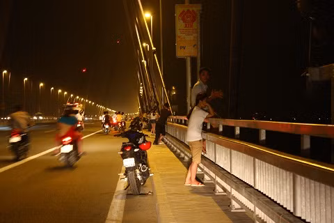 Hình ảnh người đàn ông ngồi trên thành cầu khiến ai đi qua cũng phải hoảng hồn.