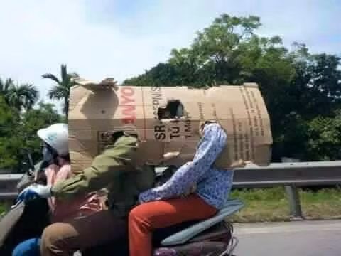 Chống nắng nóng bằng bìa các tông là phương thức được rất nhiều người lựa chọn khi di chuyển trên đường.
