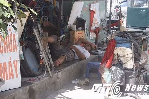 Tại một tiệm sửa chữa xe máy nhỏ bên đường, anh thợ này đang dành cho mình một giấc ngủ trưa trên thềm nhà sát vỉa hè.
