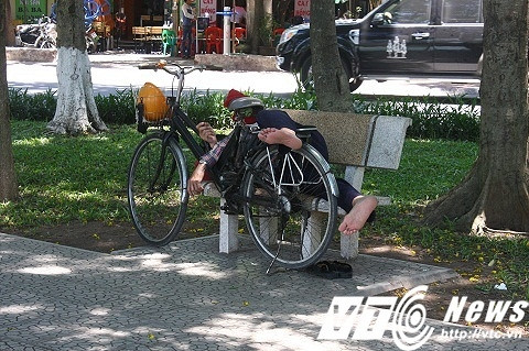 Dù đang ngủ giữa trời nắng nóng nhưng người đàn ông này không quên bảo vệ tài sản của mình.