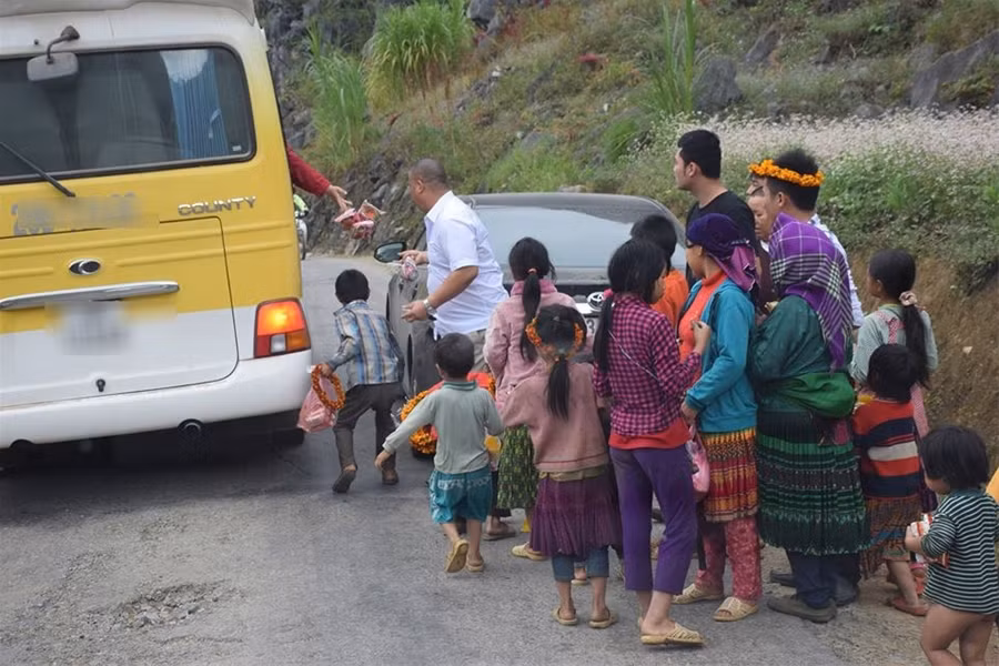 Những đứa trẻ chạy theo xe khách để nhặt quà.