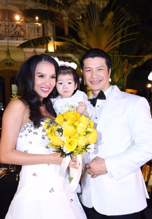 Cô con gái lớn của Dustin Nguyễn và Bebe Phạm may mắn được chụp ảnh cùng bố mẹ trong lễ cưới trong khi cô em gái quá nhỏ phải nhờ một người thân trong gia đình bế.