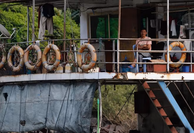Người đàn ông ngồi trên tàu trên sông Mekong.