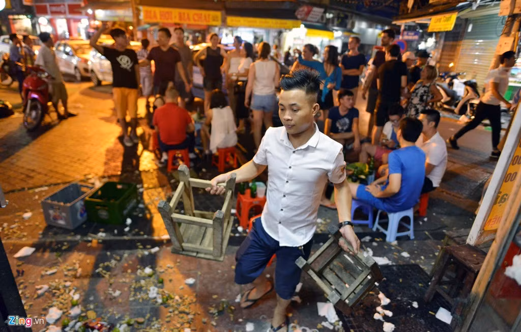 Các nhân viên vội vàng thu dọn đồ từ ngoài vỉa hè vào trong nhà.