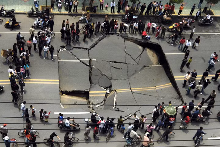 Những người hiếu kỳ vây xung quanh hố tử thần trên đường phố ở Nam Xương, tỉnh Giang Tây, Trung Quốc ngày 25/4/2007.