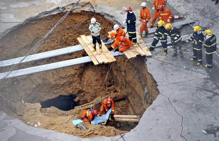 Các nhân viên cứu hộ đưa thi thể một nạn nhân ra khỏi hố tử thần trong vụ sụt lún ở Thâm Quyến, tỉnh Quảng Đông, Trung Quốc ngày 21/5/2013.