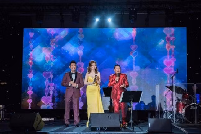 Cũng tại sự kiện này, Hoàng Kiều mặc một bộ vest màu đỏ chót với chất liệu vải bóng.