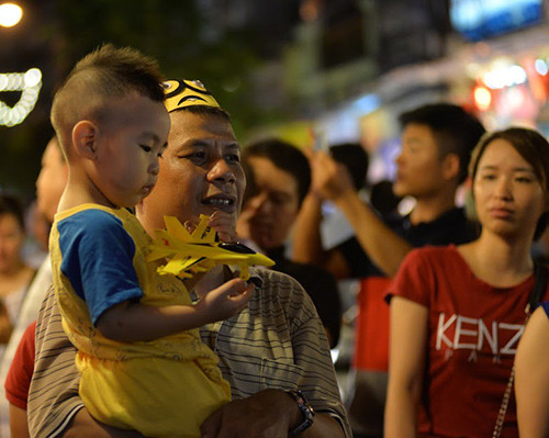 Một em nhỏ lạ lẫm bên chiếc đồ chơi nhiều màu sắc vừa được bố mua cho.