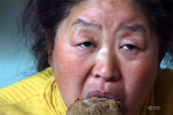 Phàn Thiên Vinh (48 tuổi) sống ở Thạch Gia Trang, Hà Bắc, Trung Quốc được phát hiện chỉ thích ăn đất trong nhà năm 2010.