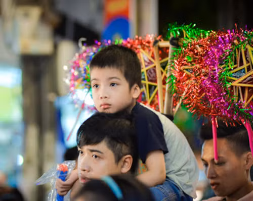 Các em nhỏ theo bố mẹ xuống phố vui chơi trung thu sớm.