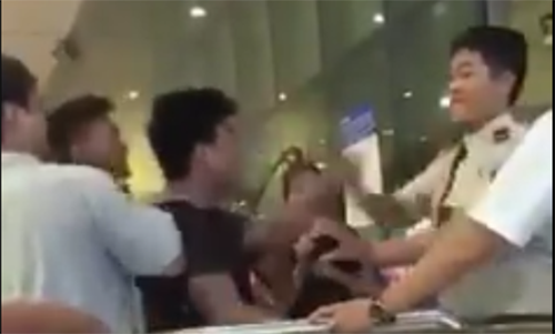 Người thanh niên (áo đen) chửi bậy, nhổ nước bọt vào nhân viên sân bay Tân Sơn Nhất. Ảnh cắt từ clip.