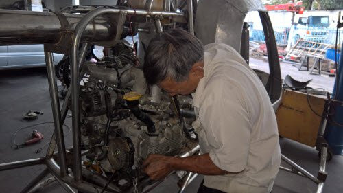 Ông Hiển đang dùng sức để vặn cứng từng con ốc ở nắp động cơ.