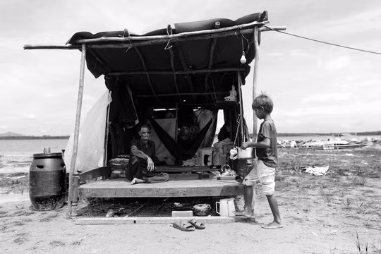 Một hộ dân mới chuyển tới xóm Việt Kiều sinh sống. Ngôi nhà di động sơ sài tới mức gió có thể thổi bay bất cứ lúc nào. Cuộc sống khó khăn đeo bám, kiếm miếng ăn còn khó, không ai ở đây dám nghĩ tới một căn nhà tốt hơn.