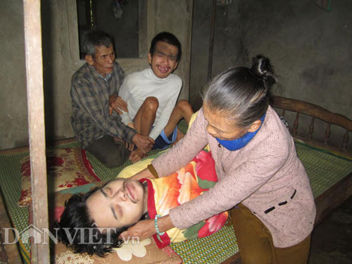 Từ lúc mới sinh ra, hai đứa con Nguyễn Văn Trường (28 tuổi - ngồi) và Nguyễn Văn Lanh (32 tuổi - nằm) của vợ chồng ông bà Lê Thị Mít (66 tuổi) - Nguyễn Văn Lộc (70 tuổi, trú thôn Phương An, xã Cam Nghĩa) đã bị dị tật, chân tay co quắp, không nói, không đi được, thiểu năng trí tuệ. Mọi việc sinh hoạt, ăn uống của hai con ông bà phải phục vụ. Thậm chí, ông bà còn bị con mình đánh mỗi khi chúng lên cơn điên dại. Đứa con trai đầu của vợ chồng bà Mít cũng đã qua đời khi mới tròn 4 tuổi.