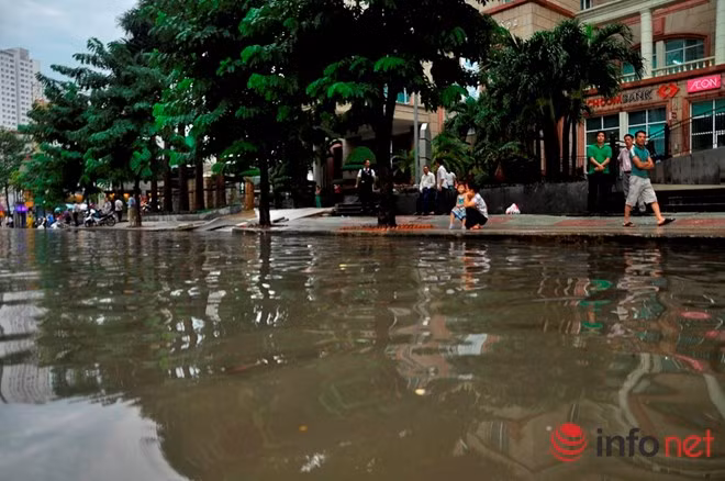 Trên vỉa hè, nhiều người dân cũng phải ngán ngẩm cảnh ngập nước và tìm lối thoát ra khỏi con đường Nguyễn Hữu Cảnh lúc tan tầm.