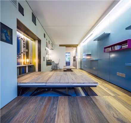 Tuy nhiên, đó mới chính là điểm đặc biệt nhất của ngôi nhà. Vì diện tích hẹp nên kiến trúc sư đã nâng sàn phòng khách lên 30cm, ốp gỗ và sử dụng hệ thống bàn nâng, giường nâng.