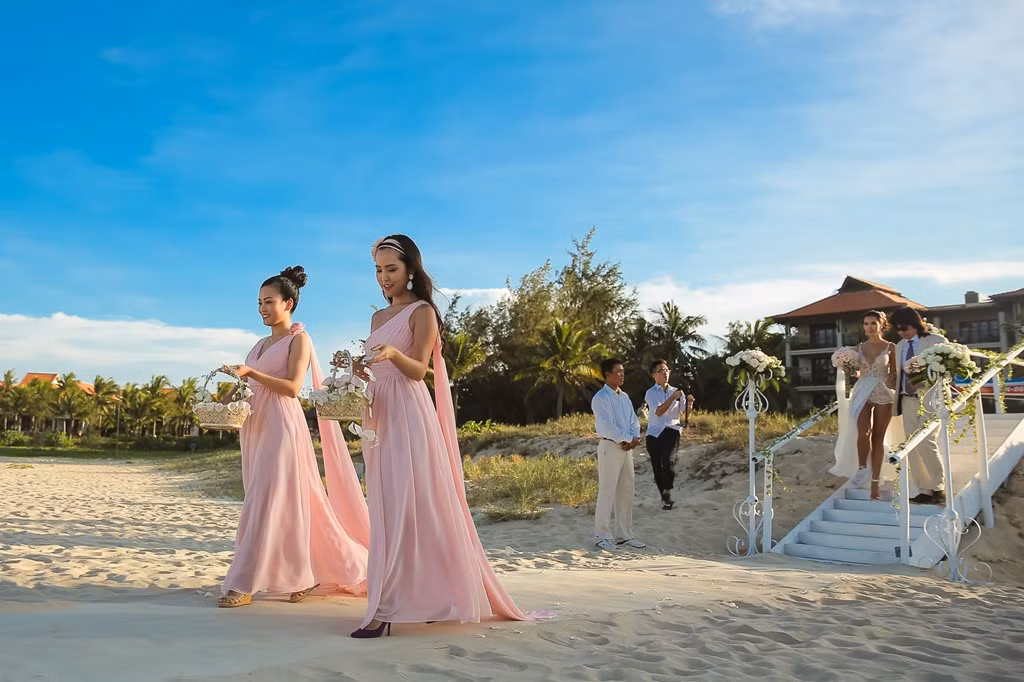 Bố Hà Anh - họa sĩ Huy Vũ - nắm tay con gái tiến ra bãi biển, nơi chú rể Olly Dowden và 60 khách mời chờ đợi.