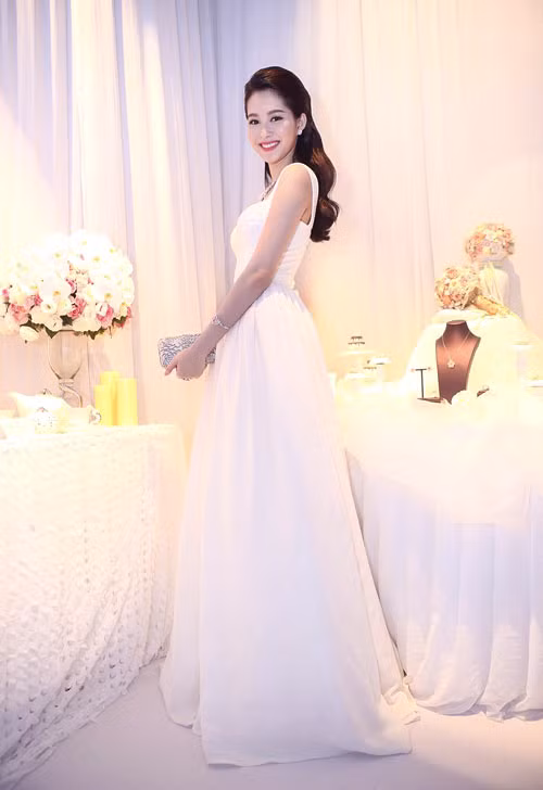 Clutch ánh kim nổi bật góp phần làm hoa hậu sinh năm 1991 sang trọng hơn với đầm đơn sắc.