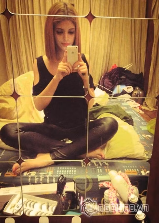 Andrea vô tư chụp ảnh mà không hề bận tâm đến căn phòng bừa bộn như "bãi chiến trường" đằng sau.