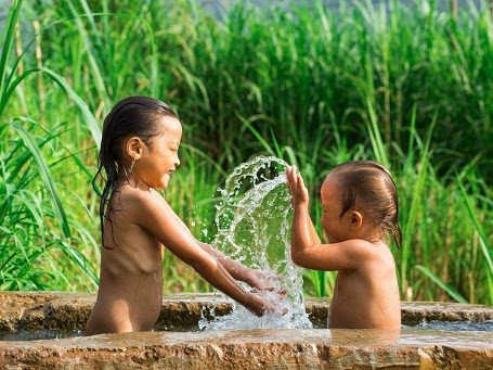 Hai em bé đang vui đùa trong lúc tắm.