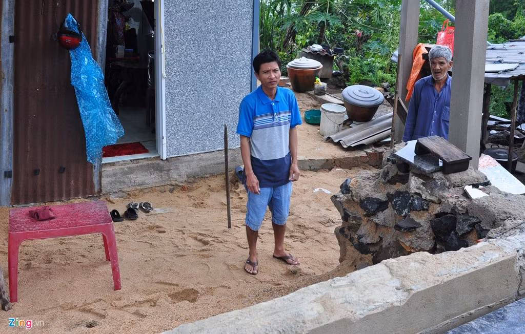 Lũ gây sụt trượt đất khiến nền nhà ông Thung sụp xuống sâu 2 m so với mặt đường quốc lộ 1.