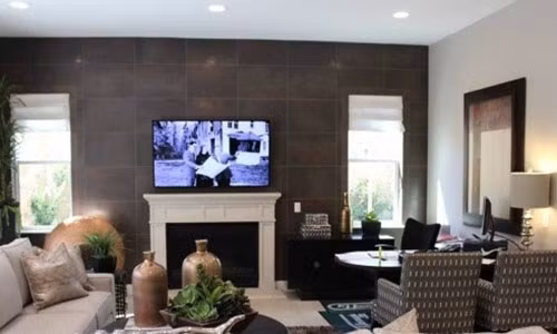 Phòng khách gồm lò sưởi, ghế salon và bàn làm việc cạnh cửa sổ.