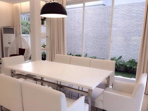 Phòng khách tạo cảm giác thoáng mát và rộng rãi. Hai màu đen trắng kết hợp rất ưa nhìn. Khu vực phòng ăn được đồng bộ màu trắng với toàn bộ nội thất trong nhà. Từ phòng ăn có thể nhìn ra không gian bên ngoài với cây xanh mát mắt.