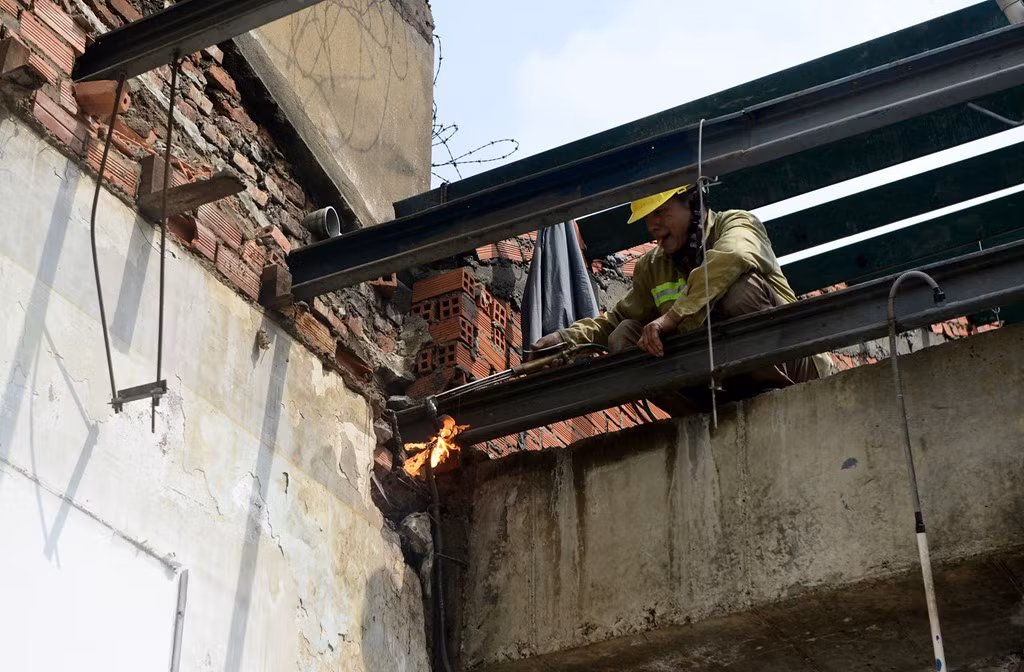 Công nhân cắt hệ thống khung mái che.