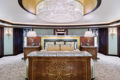 Không gian phòng ngủ rộng rãi với đèn chùm lấp lánh phía trên cùng chiếc giường sang trọng.