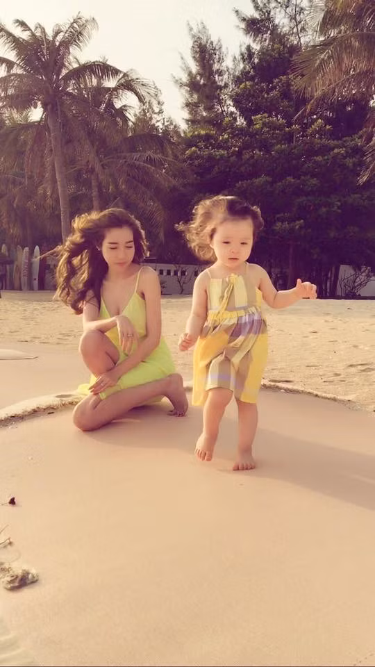 Hai mẹ con Elly Trần và Cadie cùng nô đùa trên bãi cát.