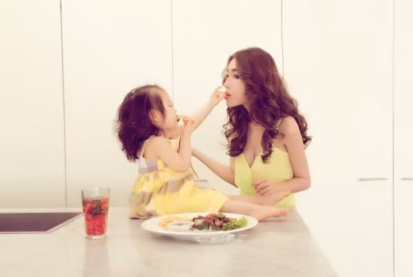 Cadie thích thú đút thức ăn cho mẹ.