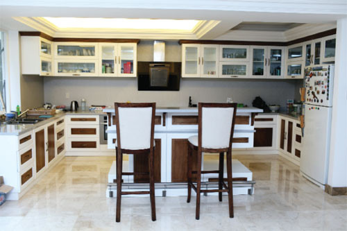 Bếp gọn gàng và sáng mắt. Tuy sử dụng nội thất gỗ nhưng không tạo cảm giác nặng nề do thiết kế đơn giản cũng như sử dụng tông màu trắng chủ đạo.